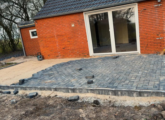 Terrassenfläche im Aufbau mit frisch verlegtem Betonpflaster