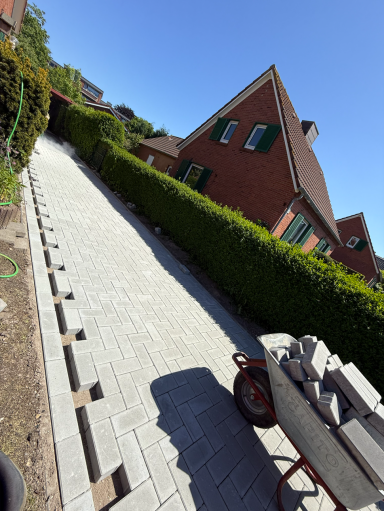 Neu gepflasterte Auffahrt mit Randsteinen an einem Wohnhaus